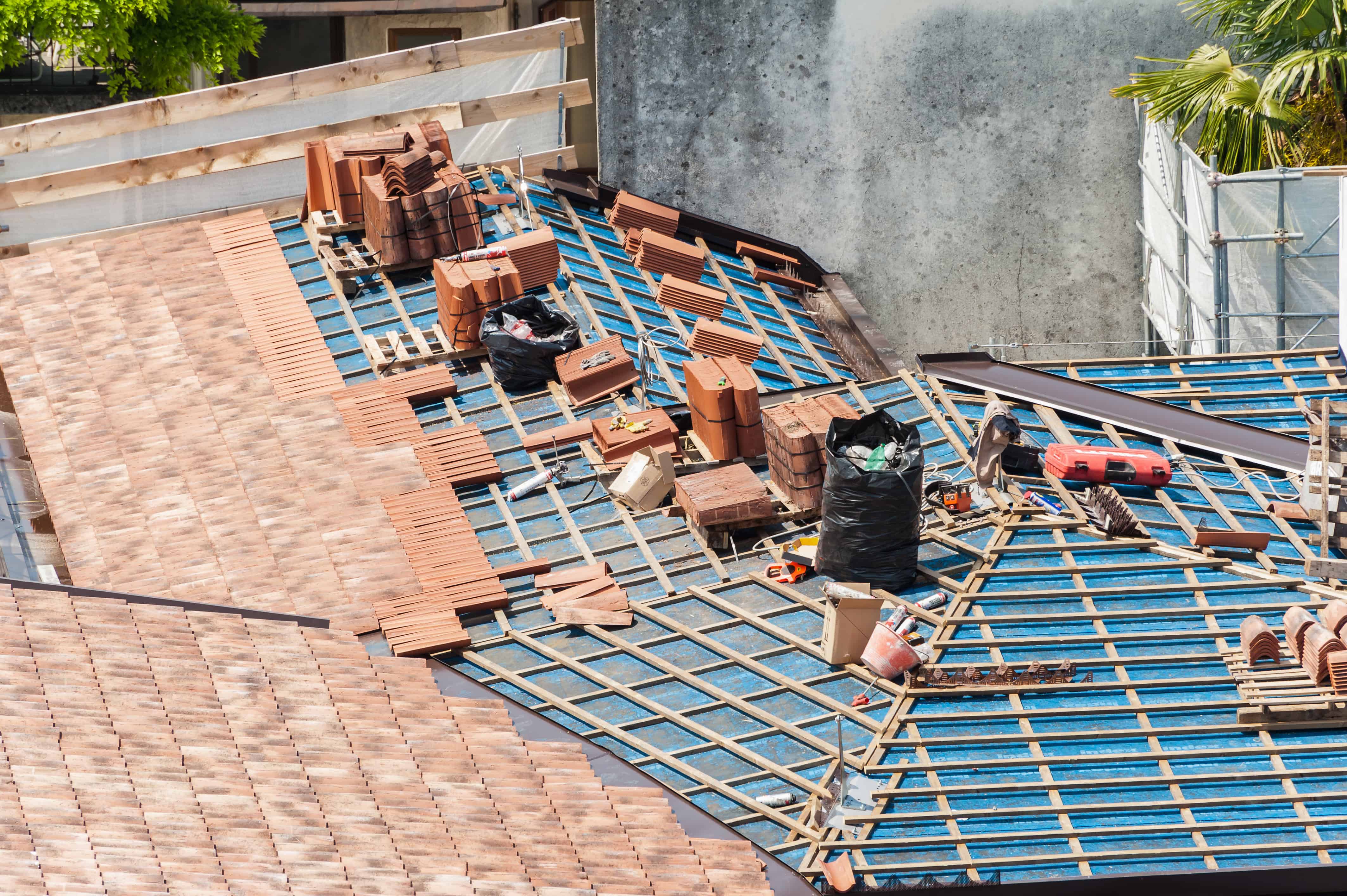 Construction de toiture avec tuiles et outils.